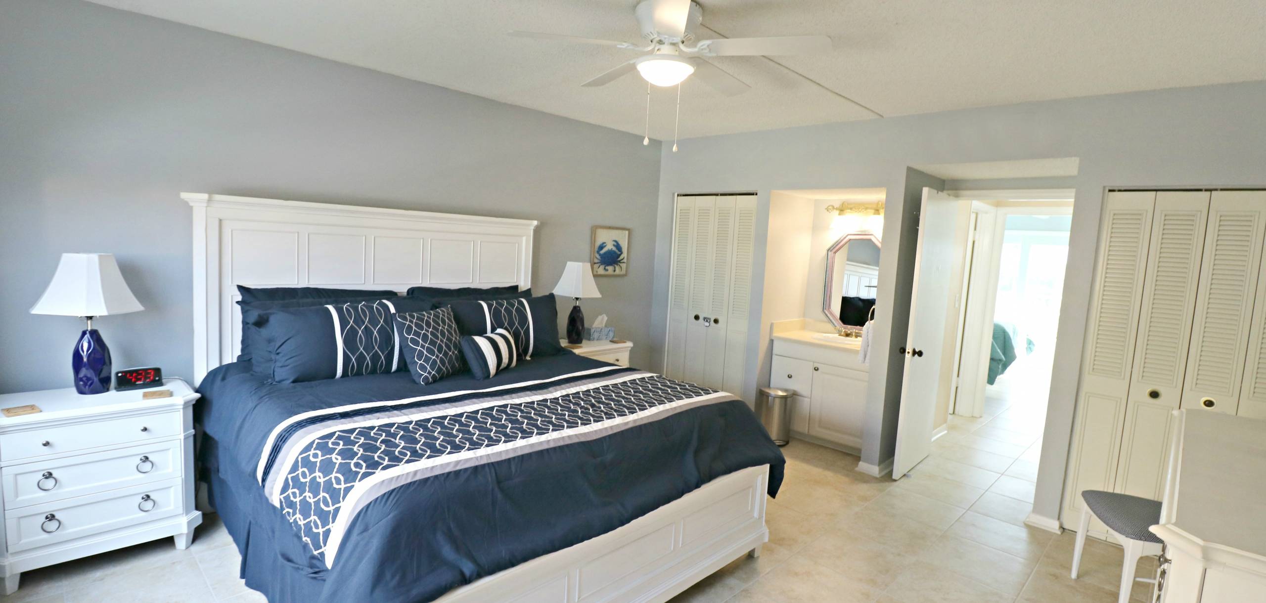bedroom at creston house florida with navy bedding and a white bed headboard and neutral decor 