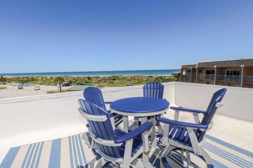 patio with blue furniture and the ocean in the distance