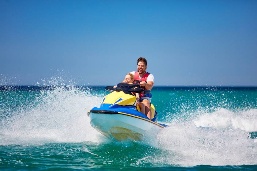 father and son on a jet ski in the ocean